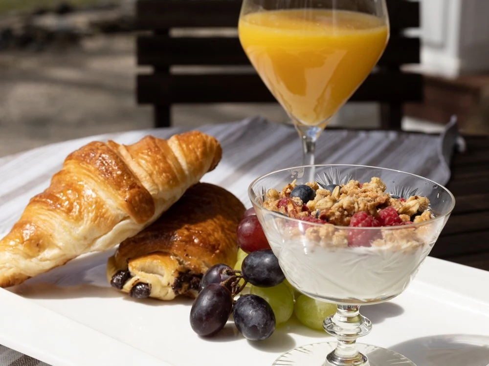 Un petit-déjeuner avec viennoiseries, yogourt, fruits et jus à La Raveaudière