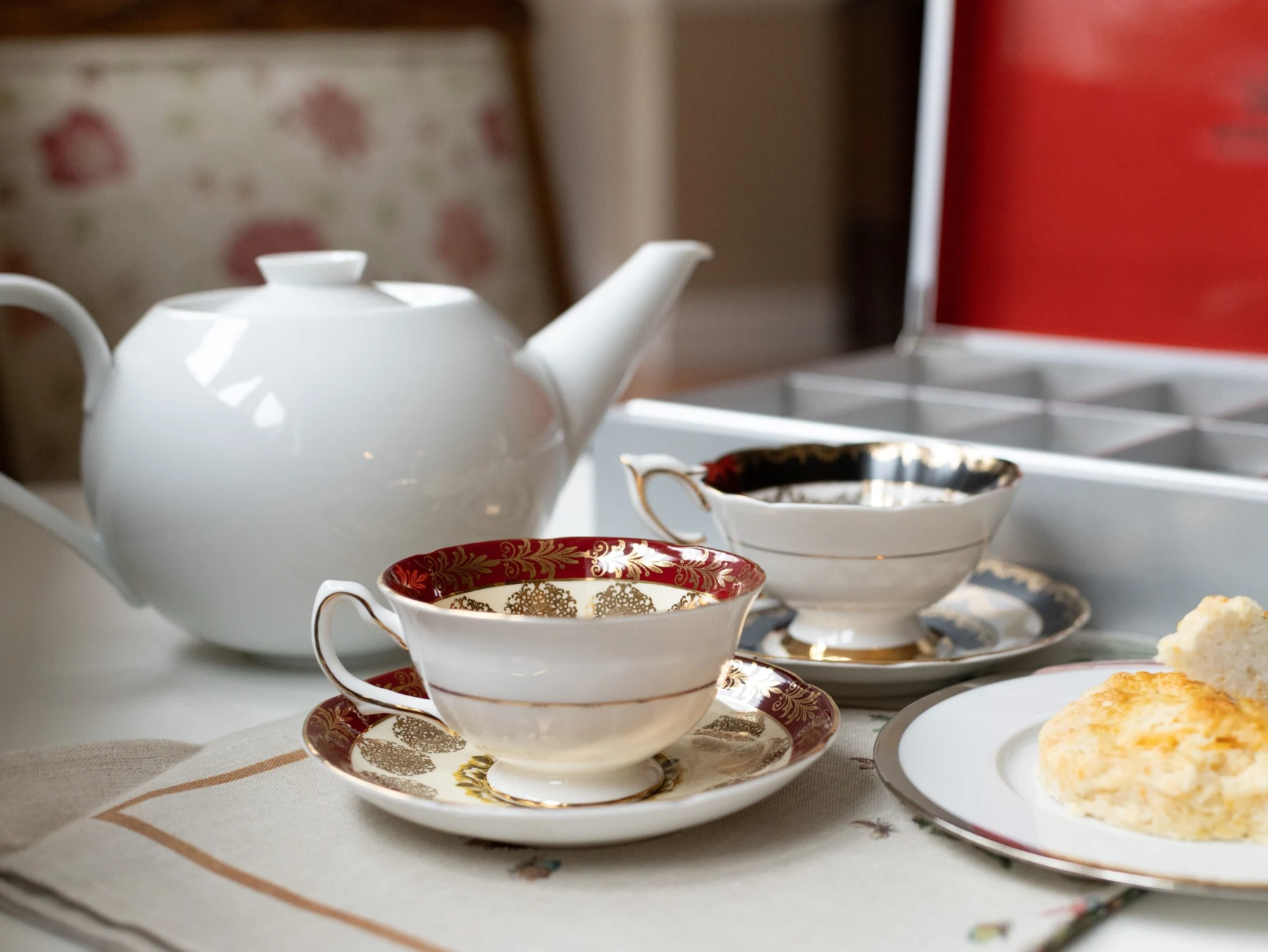 Une théière, des tasses en porcelaine et une assiette sur une table